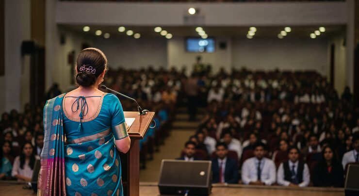 woman-teacher-saree-giving-speech-large-audience-auditorium_921835-6121
